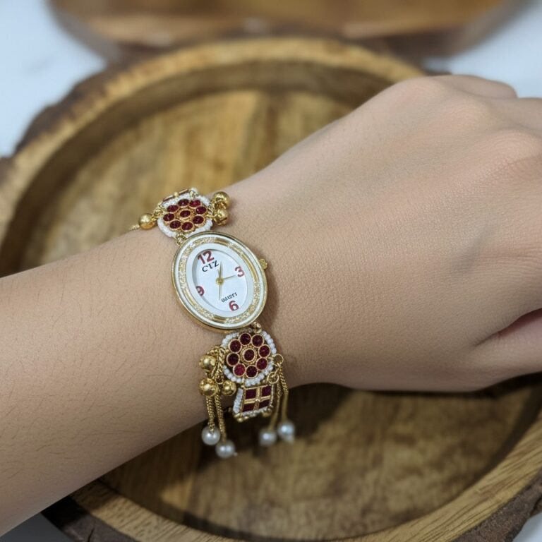 Ethnic gold watch bracelet with ruby stones, pearl drops and chain tassels on wooden tray.