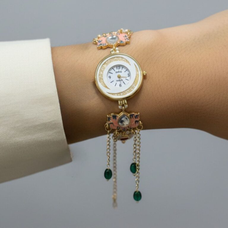 Gold boho style watch bracelet with enamel design, red stones, green bead tassels and pearl detailing