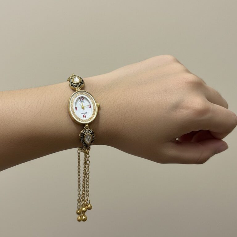 Ethnic gold watch bracelet with chain and ghungroo detailing placed on wooden tray.