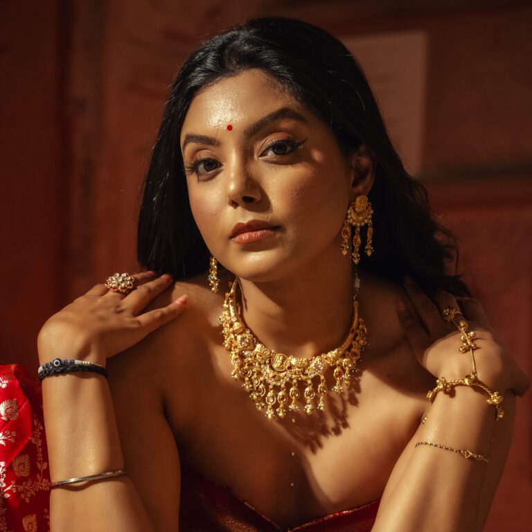 Woman wearing antique temple necklace set with matching dangling earrings.