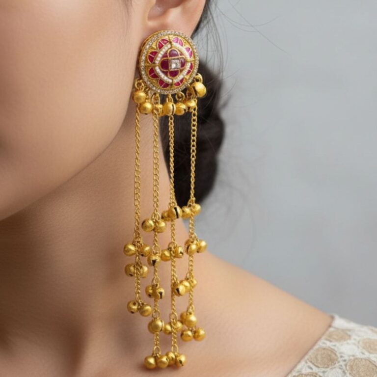 Gold Kashmiri style drop jhumka earrings with pink detailing and long chain ghungroo drops held in hand.